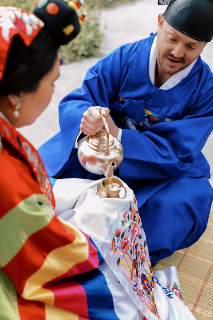 Korean wedding Tea Ceremony with bride and groom in traditional attire.