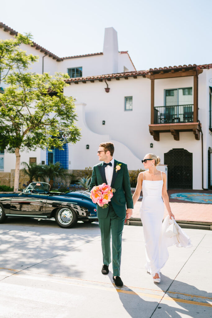 Bride and groom wearing sunglasses walking in downtown Santa Barbara. Groom wearing green tux. Wedding Photography by Jodee Debes