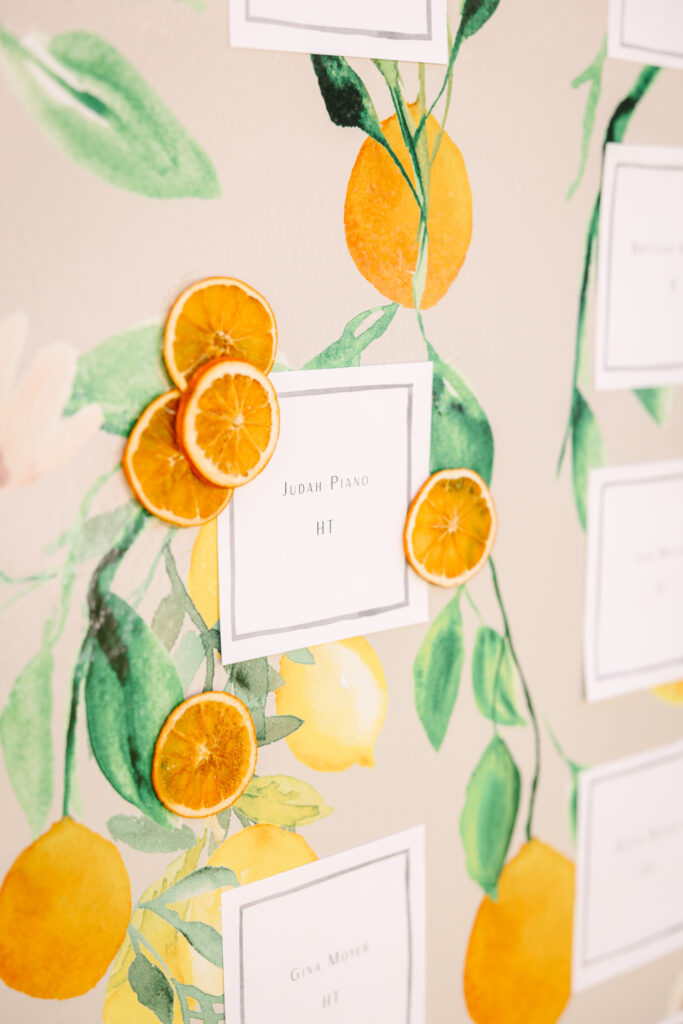 Wedding seating chart. Orange patterned escort card display wall.