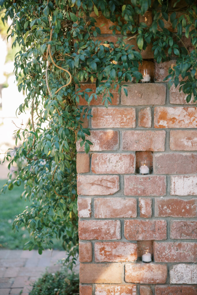 Wedding ceremony at the Belmond El Encanto hotel by the Lily Pond. Drapery hanging around the courtyard. Votive candles in the brick.