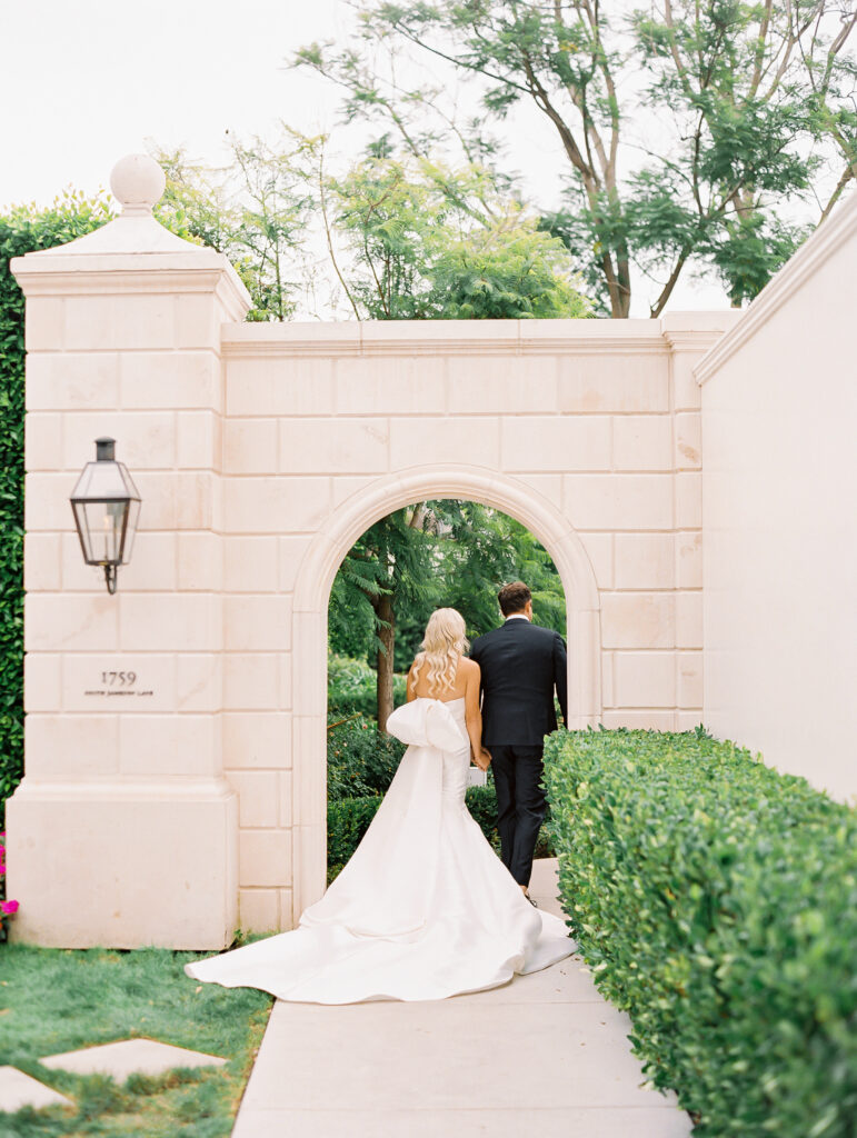 Portrait of bride and groom walking through the Rosewood Miramar Beach Resort