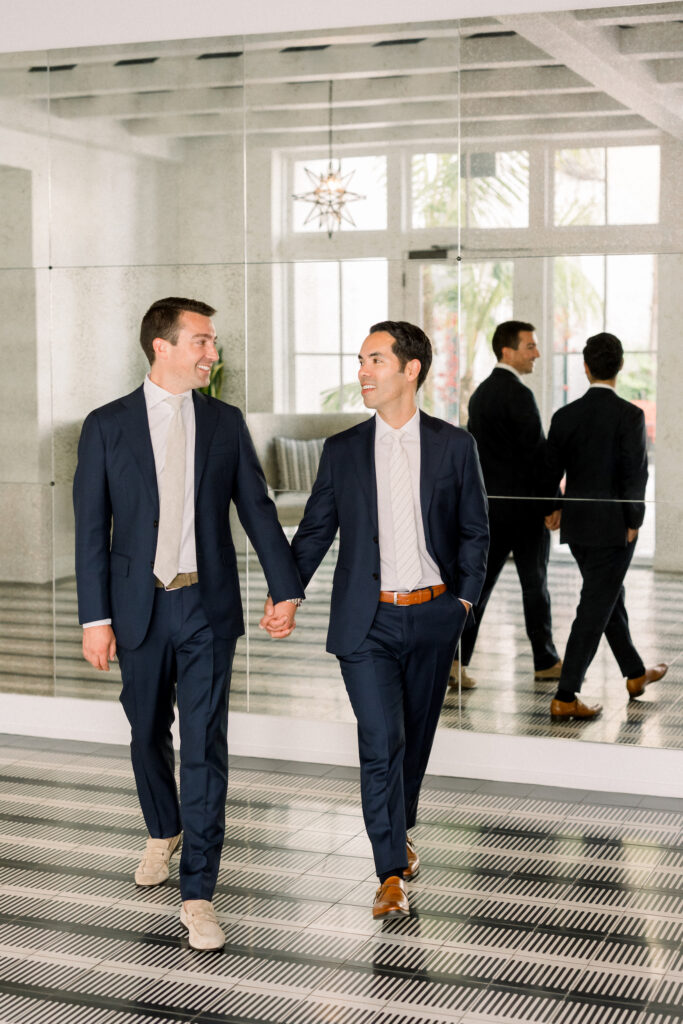 Two grooms on wedding day walking in Hotel Californian