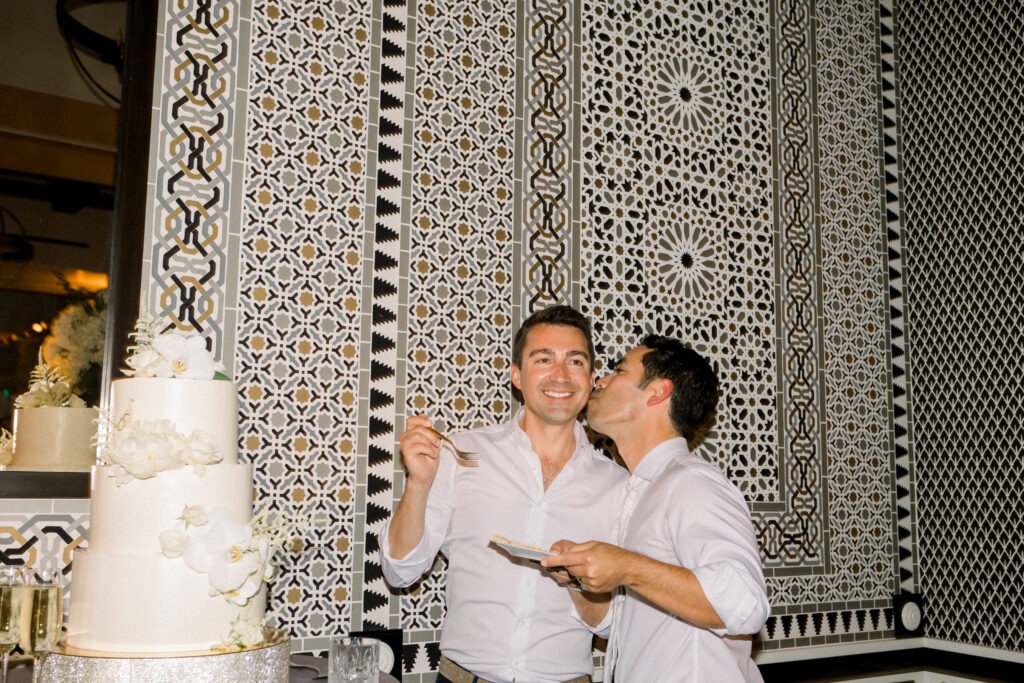 Two grooms cutting their wedding cake