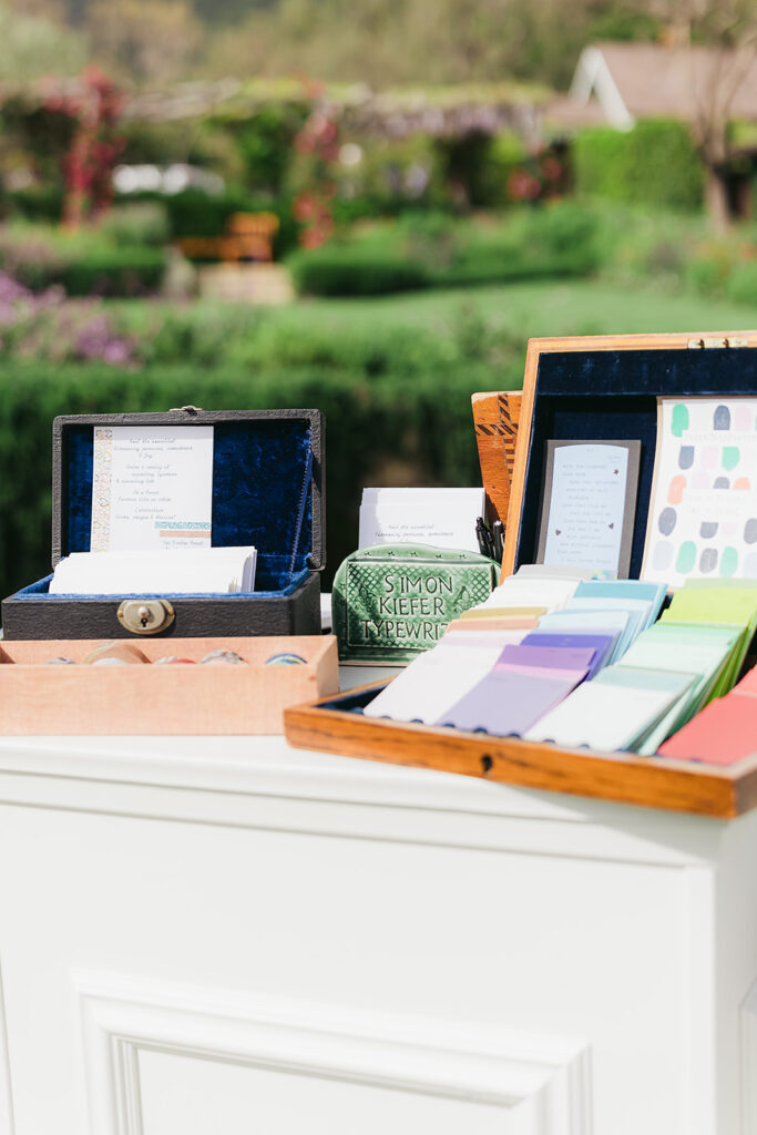 Pop-up booth at wedding cocktail hour with typewriters and poets. Typewriting poet wrote personal poems for guests at cocktail hour.