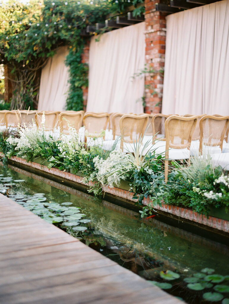 aisle florals at a quiet luxury wedding by a lily pond