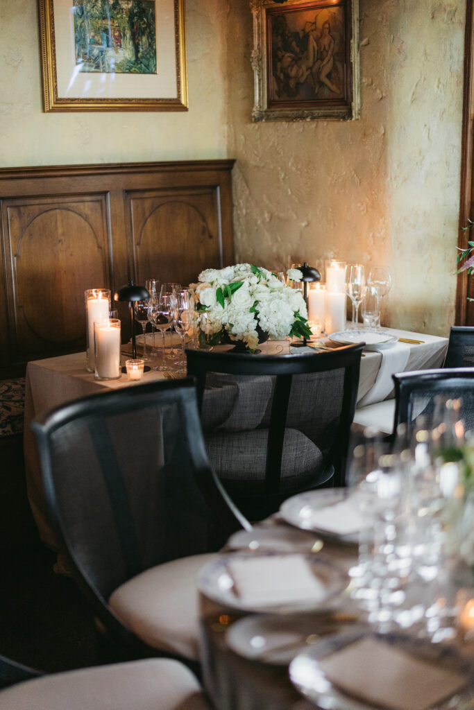 Wedding reception dinner at San Ysidro Ranch's award-winning restaurant, Stonehouse. Neutral velvet table linens, black and white upholstered dining chairs, white and green floral centerpieces.