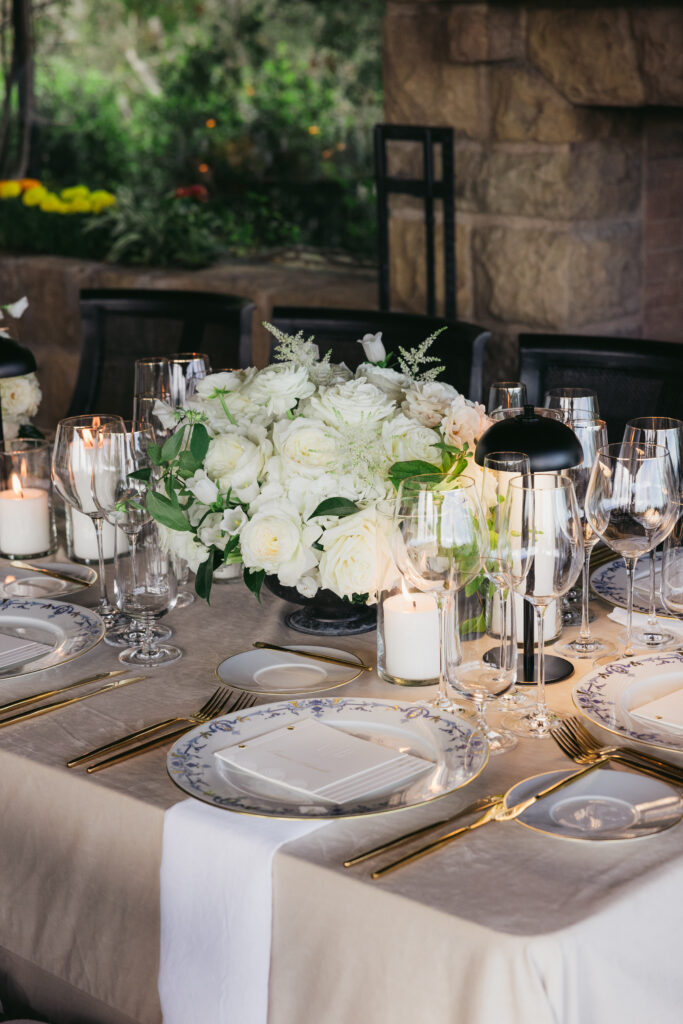 Wedding reception dinner at San Ysidro Ranch's award-winning restaurant, Stonehouse. Neutral velvet table linens, black and white upholstered dining chairs, white and green floral centerpieces.