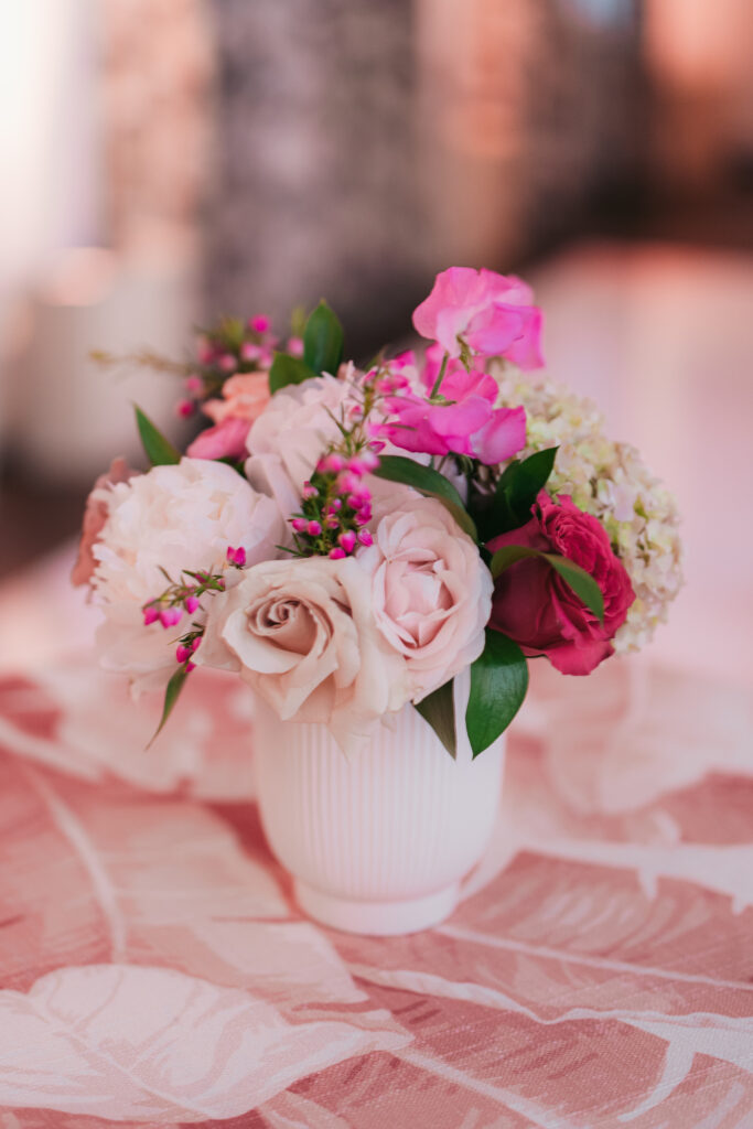 Small floral centerpiece with pink flowers on pink linen