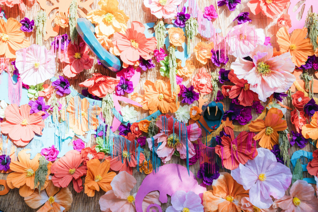 Photo backdrop with paper flowers and large snake prop