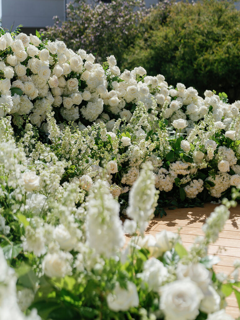 Lush white wedding ceremony flowers