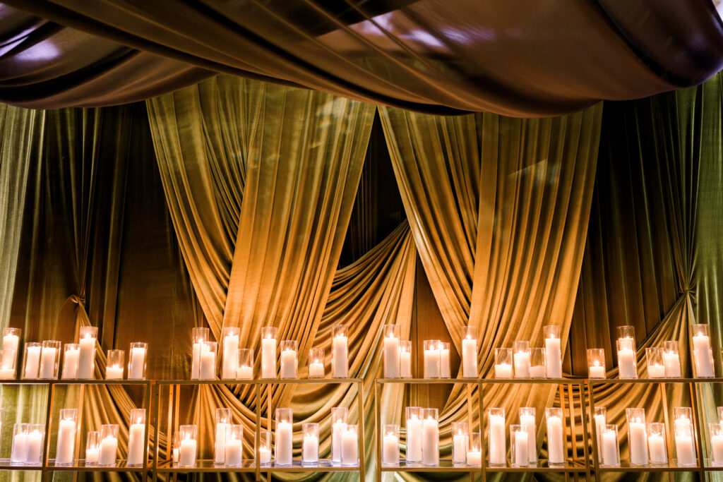 Dramatic Green velvet draping behind event bar with lots of candles