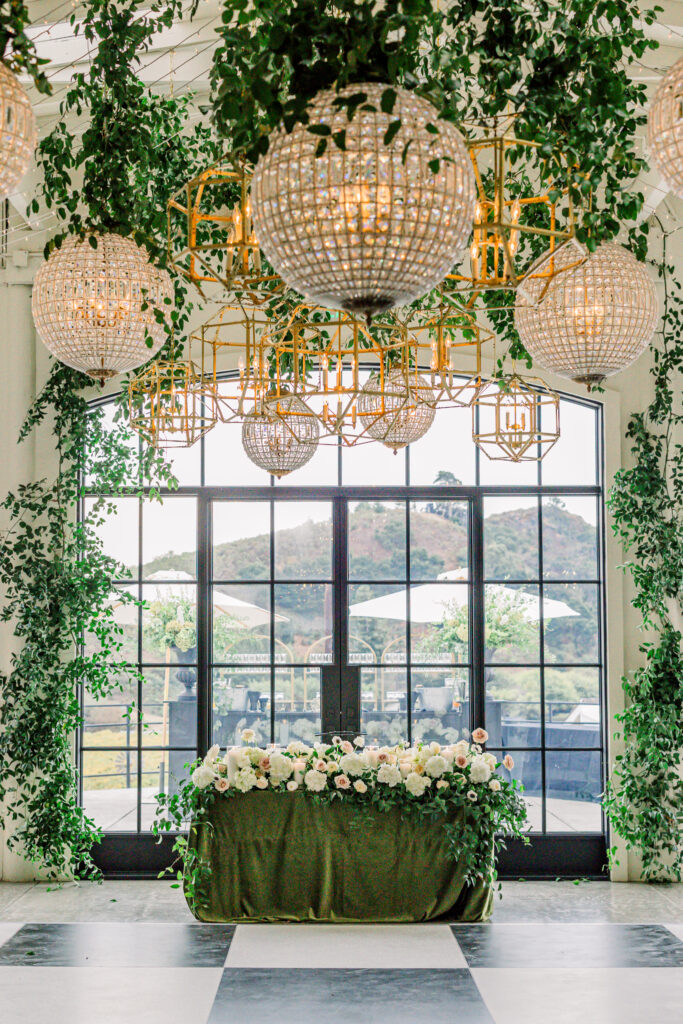 Wedding reception at Greengate Ranch & Vineyard overflowing with greenery and chandeliers