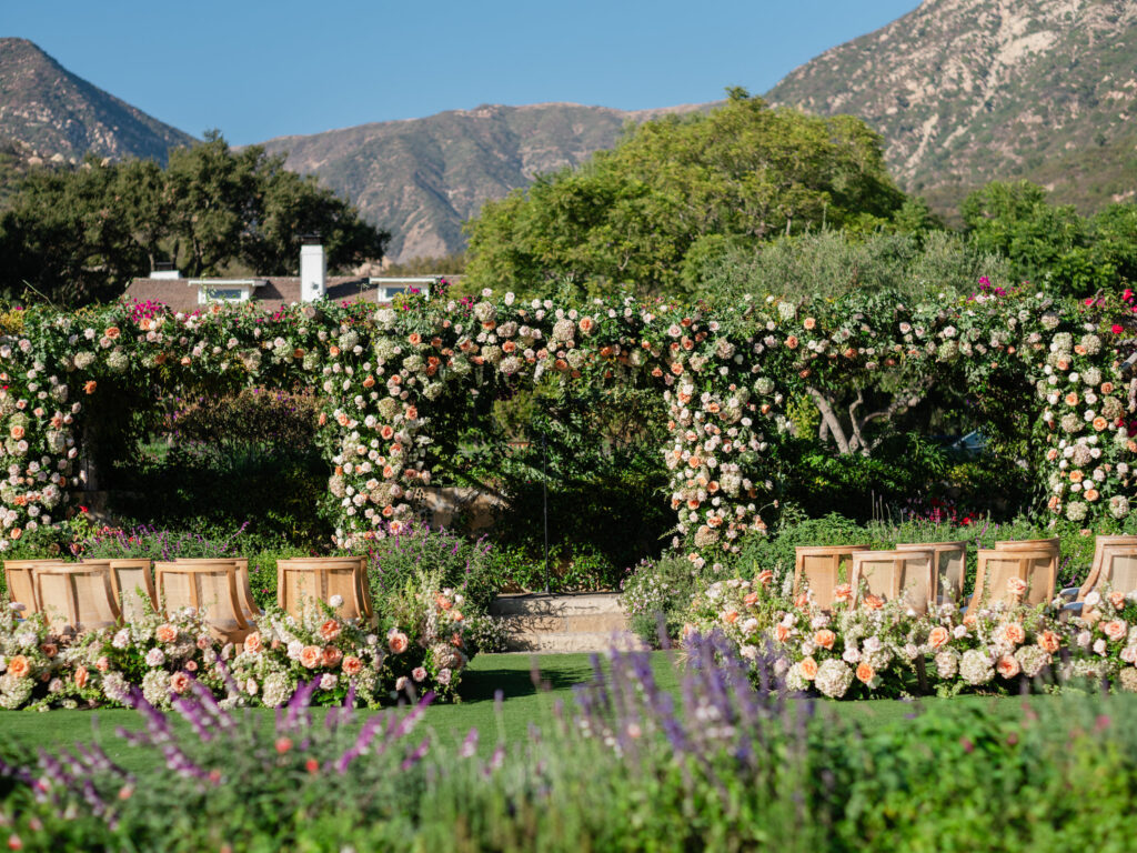 San Ysidro Ranch wedding ceremony in garden lawn with triple floral arch by Tyler Speier Events